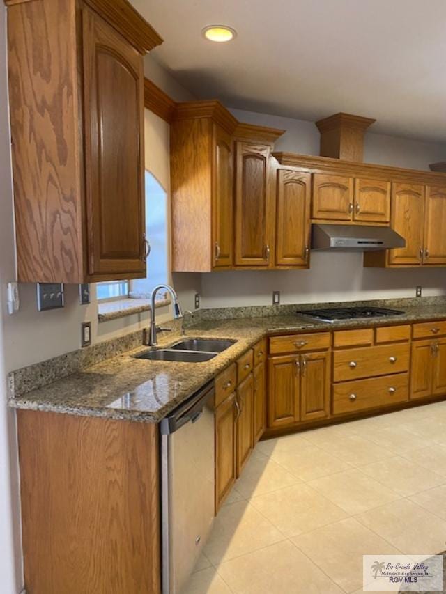 kitchen with dark stone countertops, sink, light tile patterned floors, and appliances with stainless steel finishes