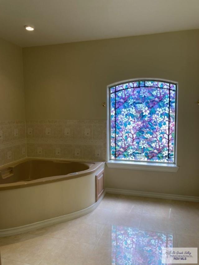 bathroom featuring plenty of natural light, a bath, and tile patterned flooring