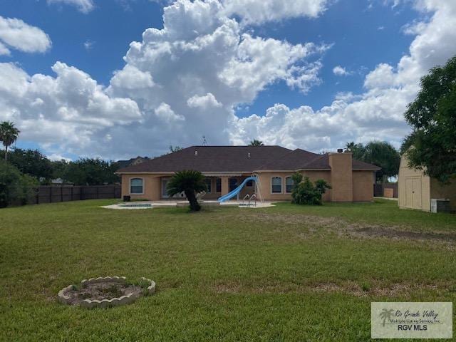 rear view of property featuring a lawn