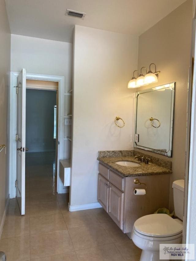 bathroom with tile patterned flooring, vanity, and toilet