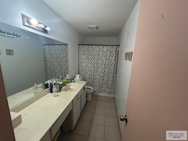 bathroom featuring vanity, tile patterned floors, a shower with shower curtain, toilet, and a textured ceiling