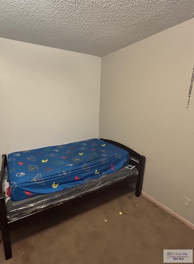 bedroom featuring carpet and a textured ceiling