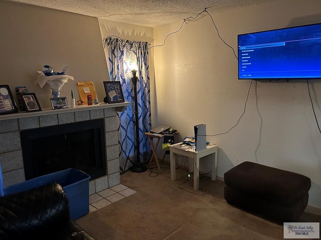 interior space with carpet flooring, a textured ceiling, and a tiled fireplace