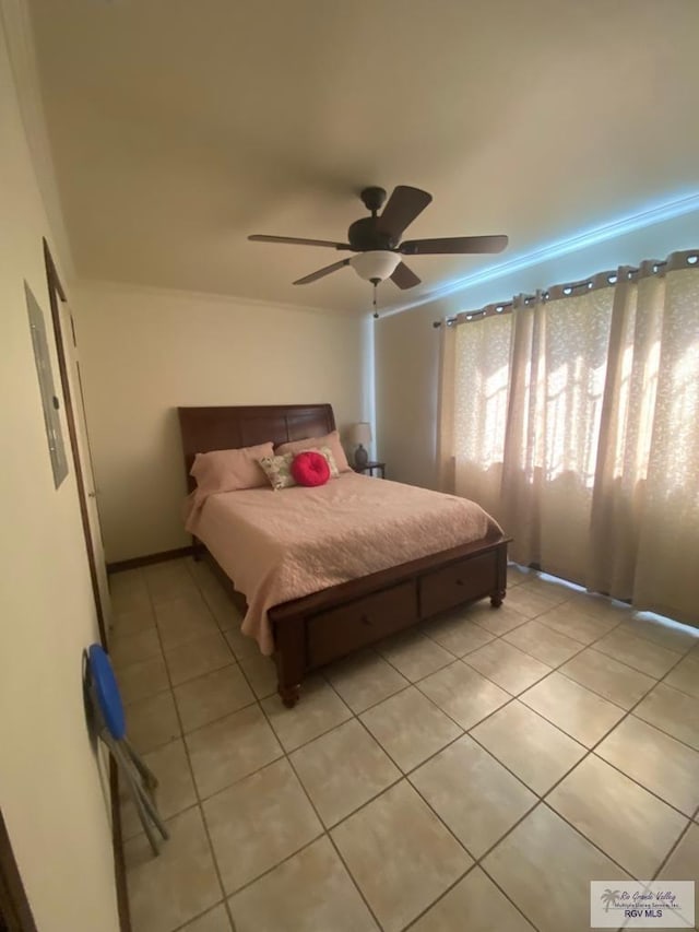 tiled bedroom featuring ceiling fan and crown molding