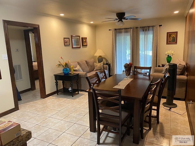 tiled dining area featuring ceiling fan and crown molding