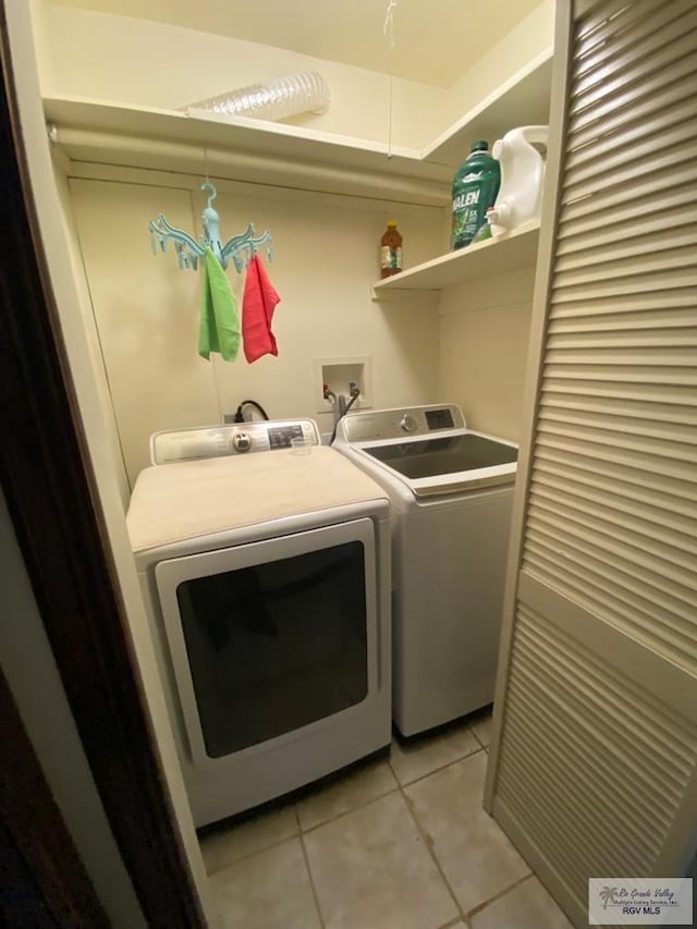 washroom featuring washing machine and dryer and light tile patterned floors