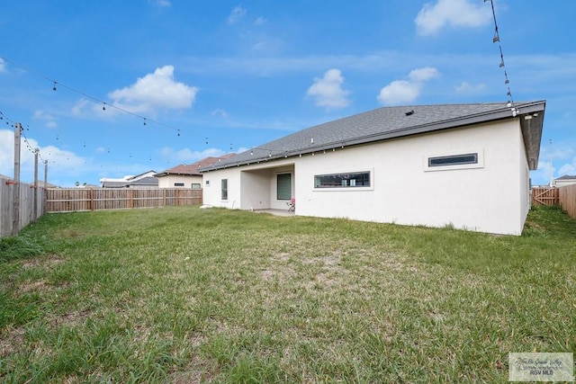 rear view of house featuring a yard