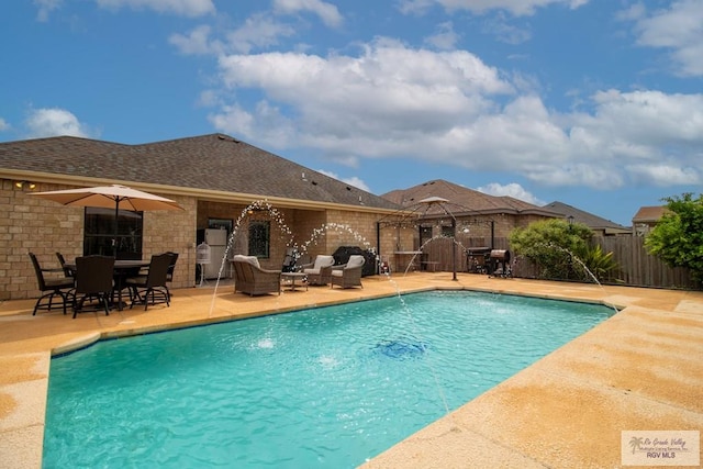 view of swimming pool with pool water feature and a patio