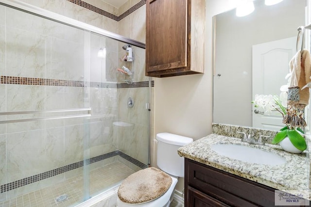 bathroom with vanity, toilet, and a shower with shower door