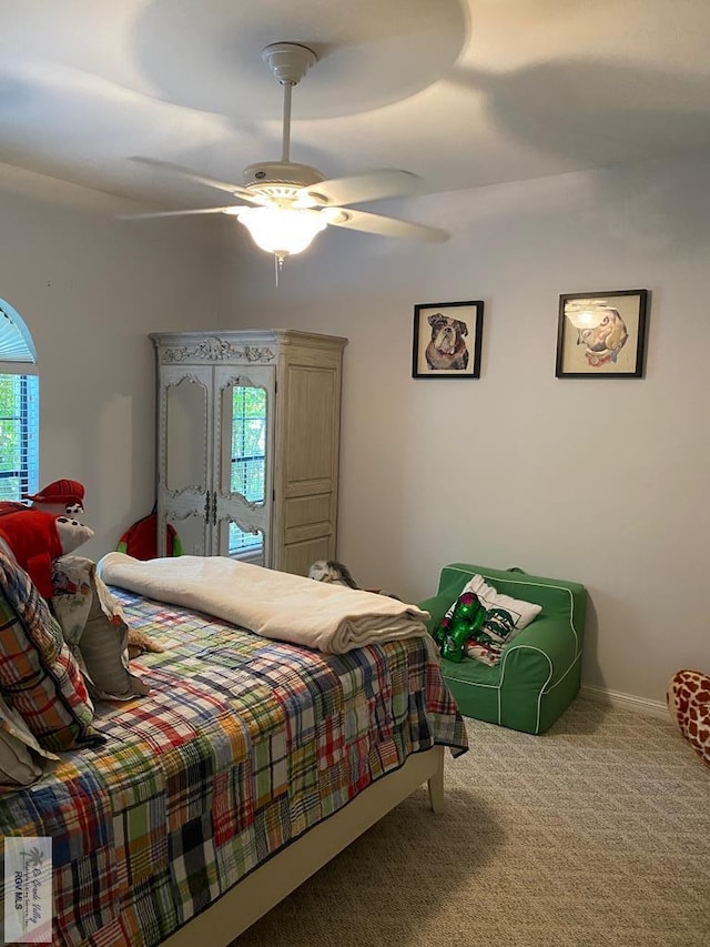 carpeted bedroom featuring multiple windows and ceiling fan