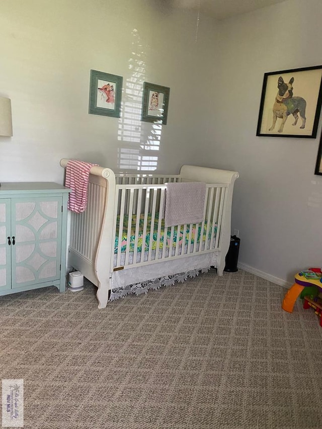 carpeted bedroom featuring a nursery area