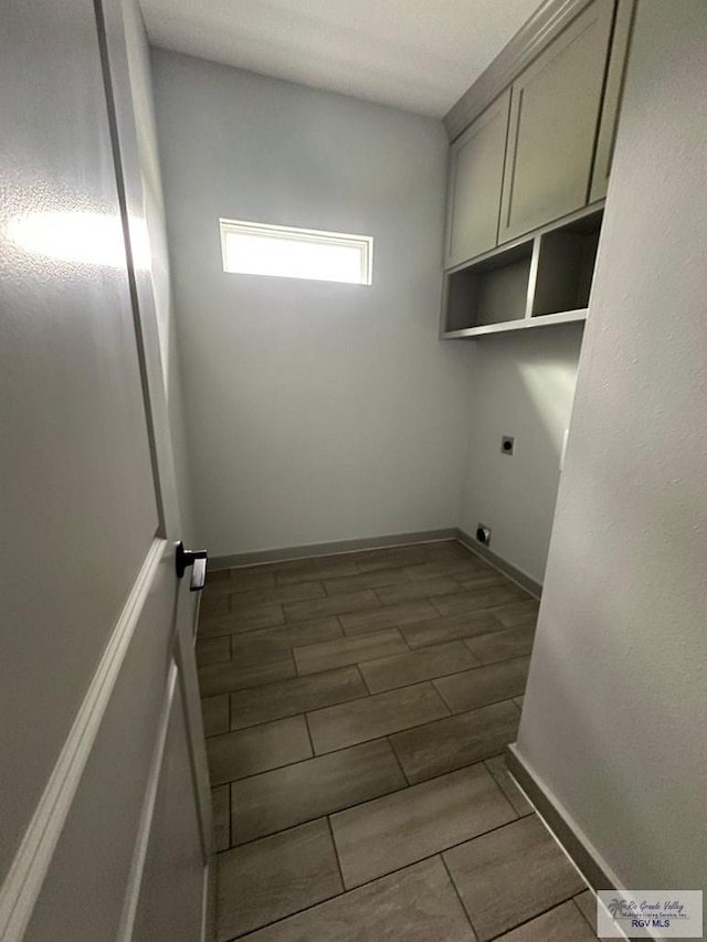2914 Brushy Ct, Harlingen, TX 78552 - washroom with electric dryer hookup, cabinet space, and wood tiled floors