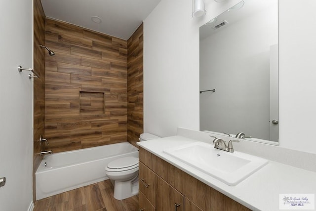 full bathroom featuring hardwood / wood-style flooring, vanity, shower / bathtub combination, and toilet