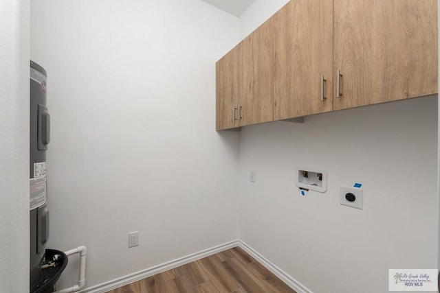 laundry room featuring cabinets, hookup for a washing machine, dark hardwood / wood-style flooring, electric water heater, and electric dryer hookup