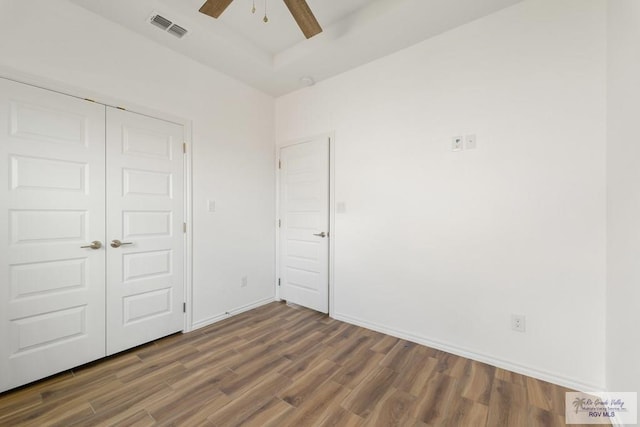 unfurnished bedroom with a closet, ceiling fan, and dark wood-type flooring