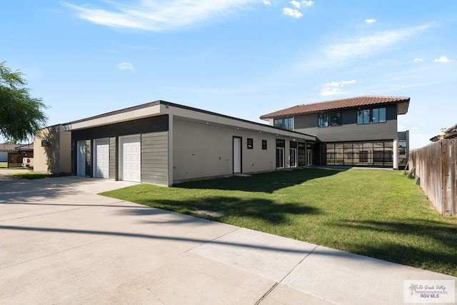 exterior space with a garage and a lawn