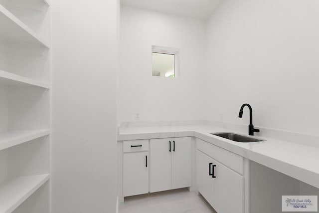 interior space with sink and white cabinets