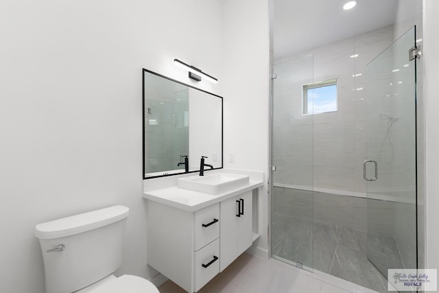 bathroom with a shower with door, vanity, and toilet