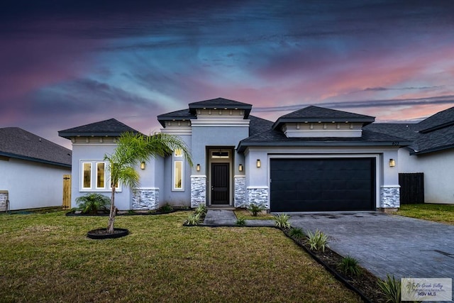 view of front facade featuring a garage and a lawn