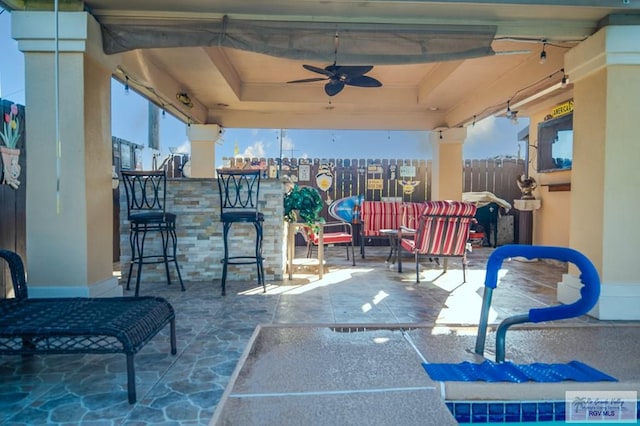 view of patio featuring ceiling fan and an outdoor bar