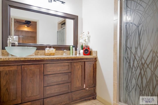 bathroom featuring tile patterned flooring, vanity, and a shower with shower door