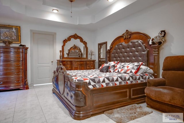 bedroom featuring a raised ceiling and light tile patterned flooring