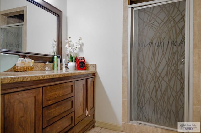 bathroom featuring tile patterned flooring, vanity, and walk in shower