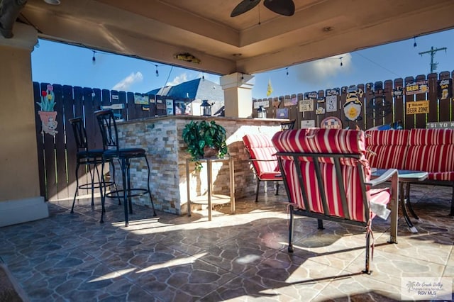 view of patio / terrace featuring outdoor lounge area, ceiling fan, and an outdoor bar