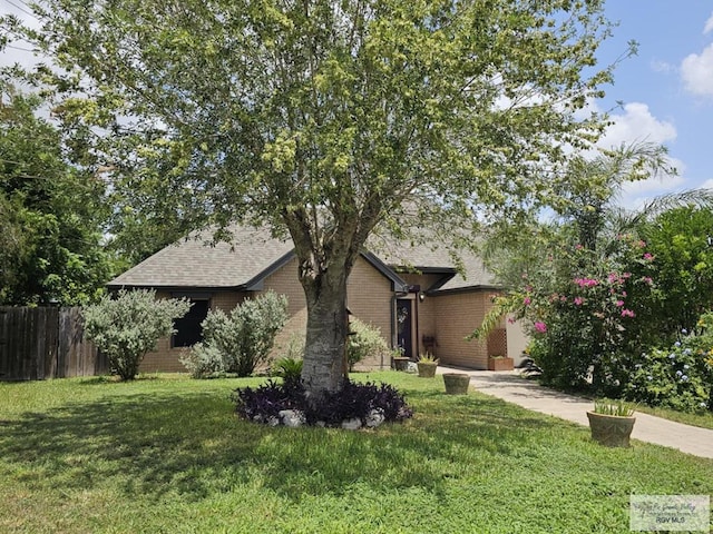 850 Grey Fox Cir, Brownsville, TX 78520 - view of property hidden behind natural elements featuring brick siding and a shingled roof