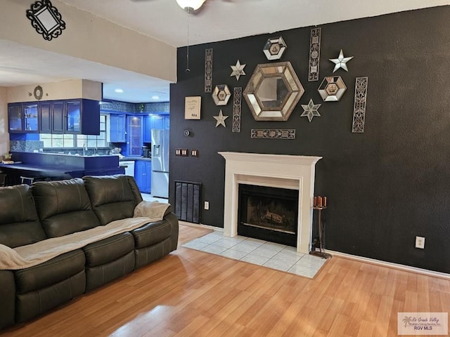 850 Grey Fox Cir, Brownsville, TX 78520 - living room with wood finished floors, a ceiling fan, and a fireplace with flush hearth