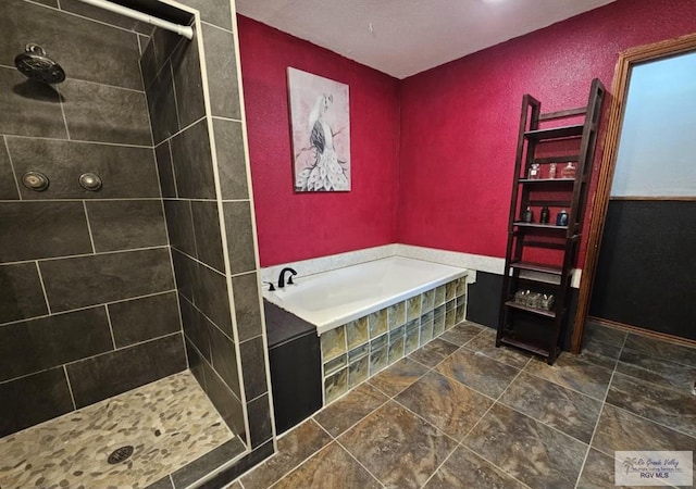 850 Grey Fox Cir, Brownsville, TX 78520 - bathroom with a bath, tiled shower, stone finish floors, and a textured wall