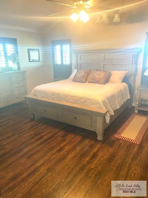 bedroom with ceiling fan, dark hardwood / wood-style flooring, and ornamental molding