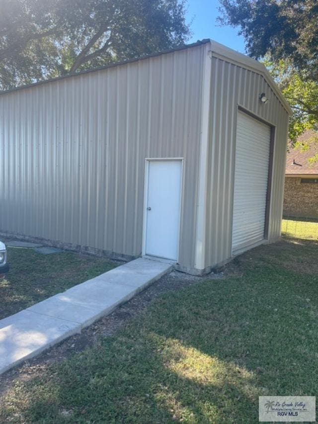 view of outdoor structure with a garage and a yard