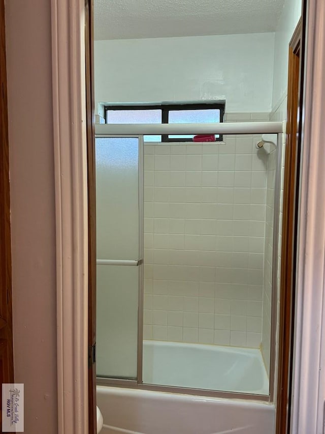 bathroom featuring toilet and enclosed tub / shower combo