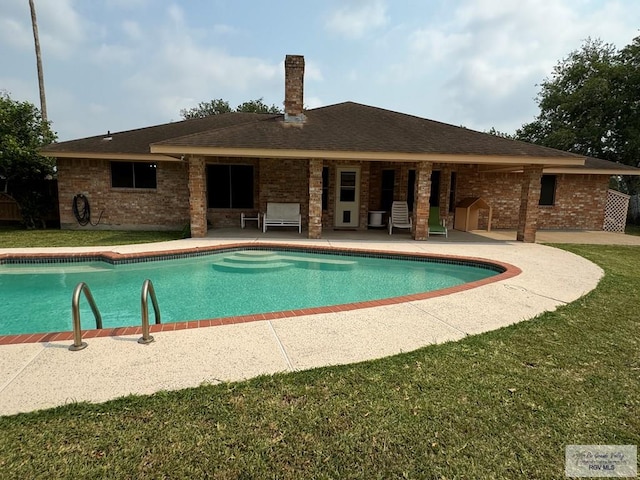 view of pool featuring a yard and a patio