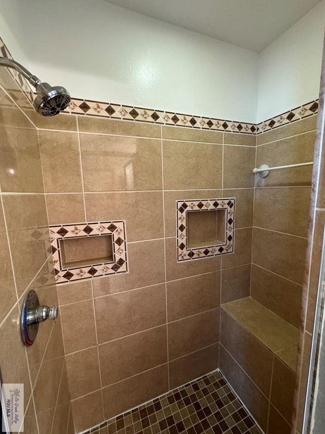 bathroom featuring tile patterned floors and a tile shower