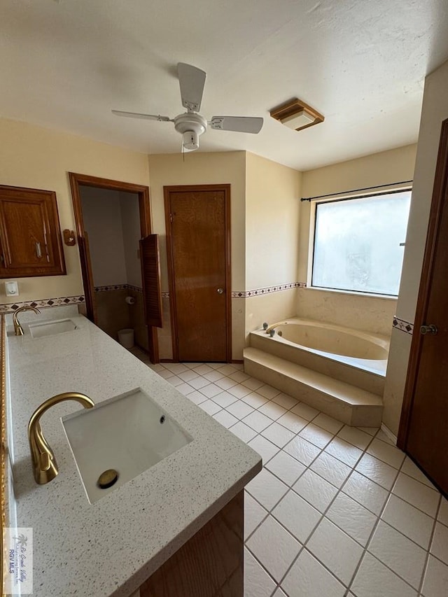 bathroom featuring a washtub, vanity, tile patterned floors, and ceiling fan