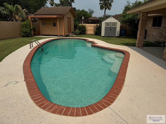 view of pool featuring a lawn and a shed