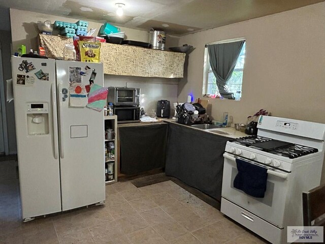 kitchen featuring white appliances and sink