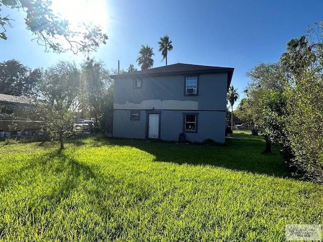 rear view of property featuring a yard