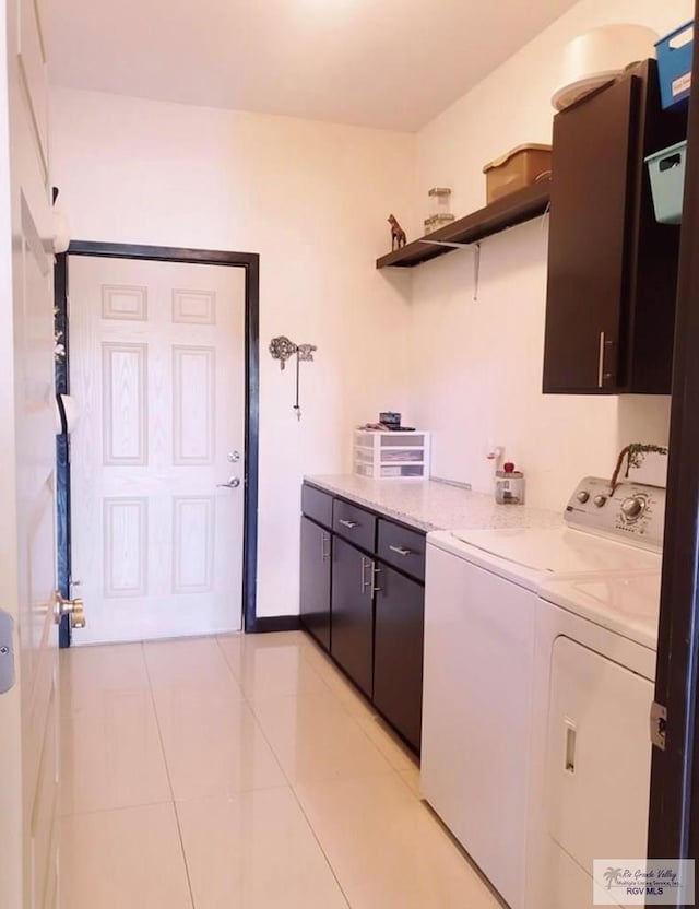 interior space with washer and clothes dryer, light tile patterned flooring, and cabinets