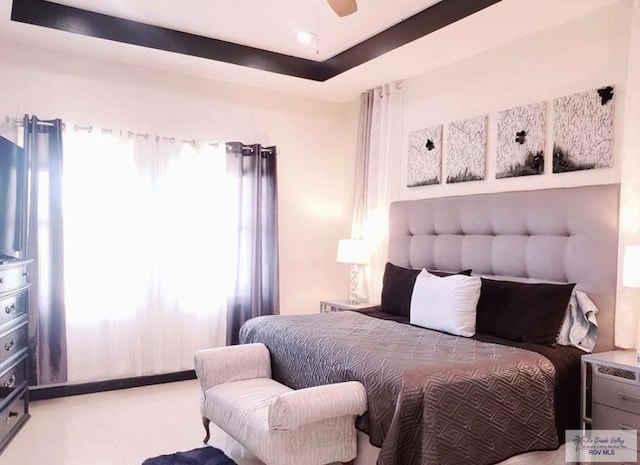 bedroom with a tray ceiling and ceiling fan