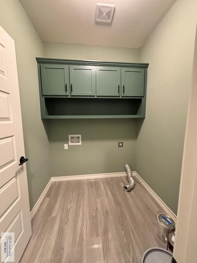 washroom with cabinets, hookup for a washing machine, and light wood-type flooring