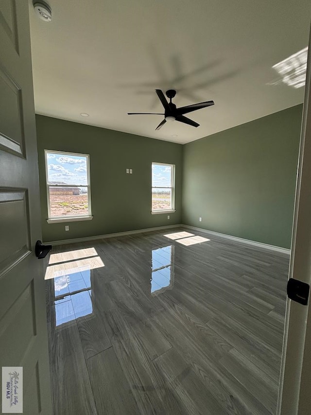 spare room featuring dark hardwood / wood-style flooring and ceiling fan