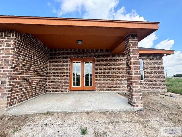 property entrance featuring a patio and french doors