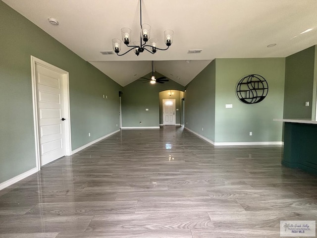 unfurnished dining area with ceiling fan with notable chandelier and lofted ceiling