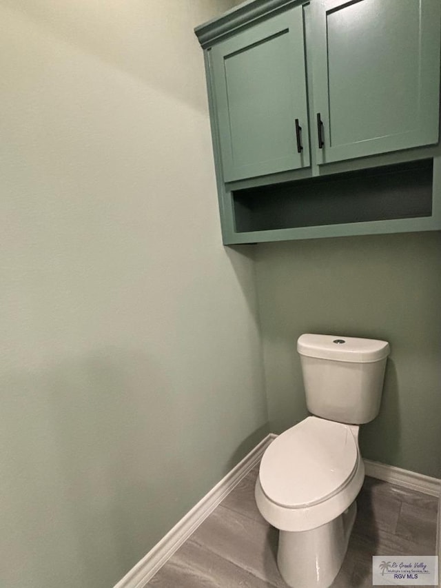 bathroom with hardwood / wood-style floors and toilet