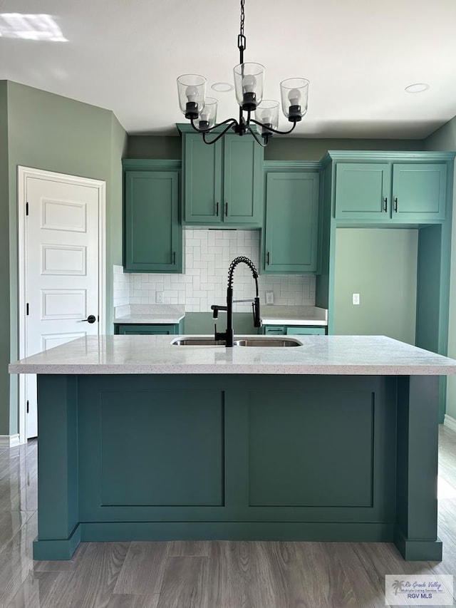 kitchen with sink, a center island with sink, and light wood-type flooring