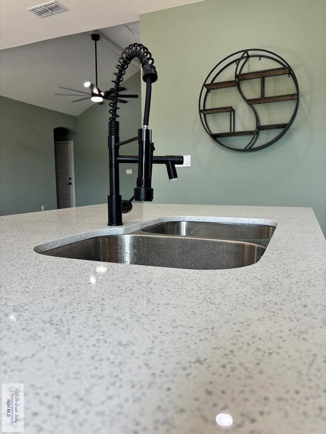 interior details featuring light stone counters and sink