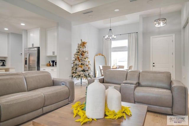 living room featuring light hardwood / wood-style floors and a notable chandelier